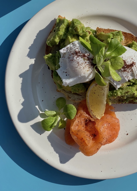 A vibrant plate of avocado toast with a poached egg and salmon, perfect for a healthy breakfast or brunch.
