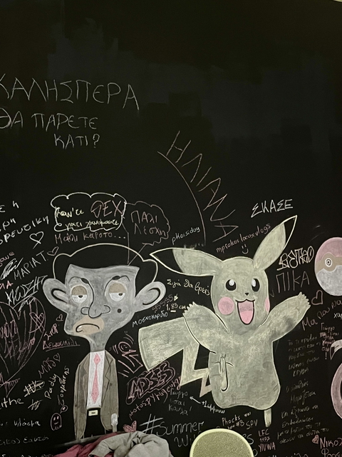 Chalk drawings of Mr. Bean and Pikachu adorn a blackboard, adding a playful touch to indoor wall decor.