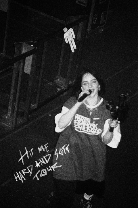 Singer Billie Eilish performs at a concert in monochrome.